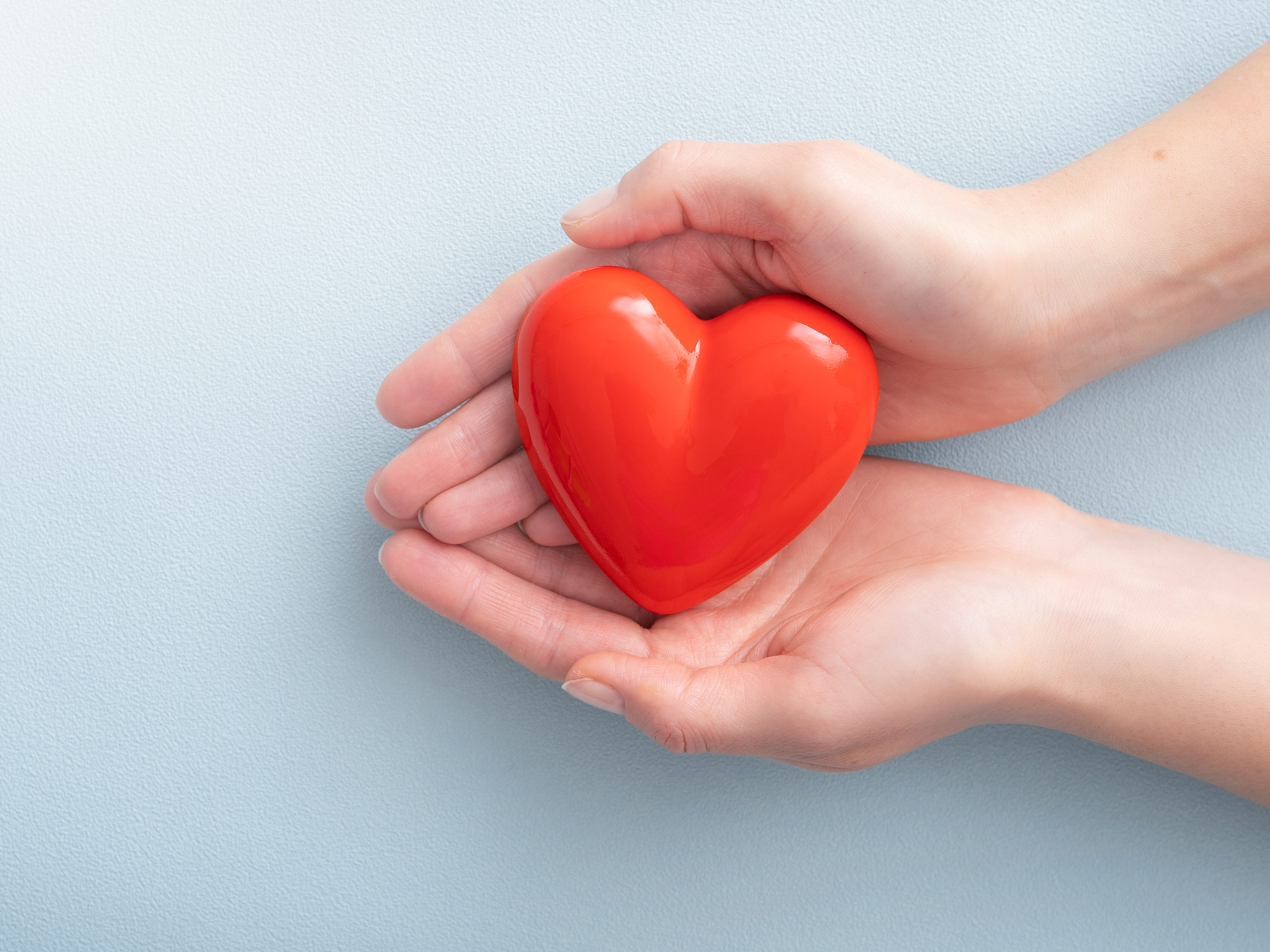 The woman is holding a red heart.